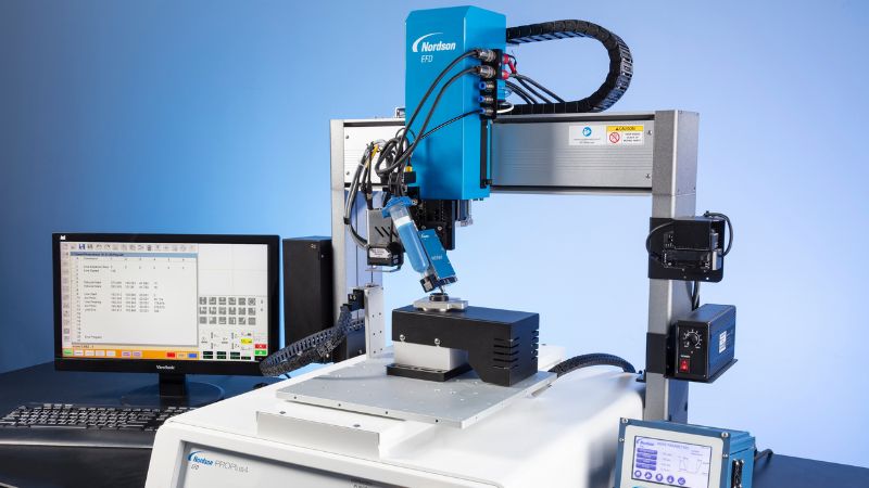 Robot ProPlus 4 assi con valvola per la dosatura automatizzata senza contatto di grasso su componente automotive.