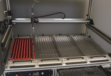 Robot cartesiano con tecnologia drylin, catena portacavi e cavi per un dispositivo di dispensing.