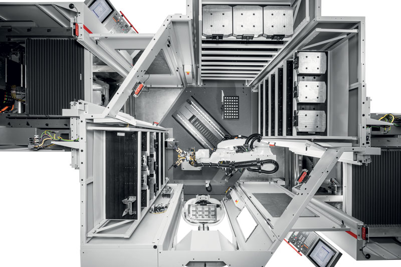 Vista dall’alto del sistema robotizzato RS 1 nell’adattamento per due centri di lavorazione Hermle C 22 U. A sinistra e destra, fino a tre moduli magazzini garantiscono un’autonomia di funzionamento alta e ospitano pallet, matrici universali e pinze.