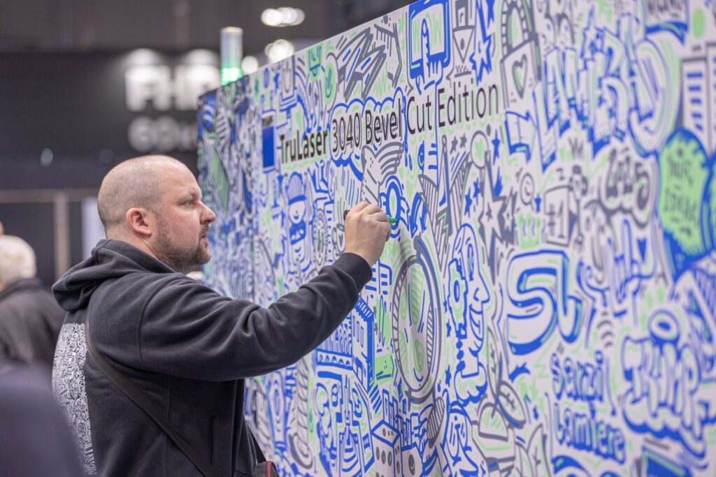 L’artista Felix Hülpüsch, in arte Hülpman, ha decorato per Sarzi Lamiere la macchina di taglio laser TruLaser 3040 Bevel Cut esposta in fiera.