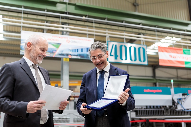 Giulio Caputo, Co-CEO CMAlifts, riceve da Tommaso Bonuzzi, Direttore Sales & Marketing Salvagnini, una targa commemorativa per l’acquisto della 4.000ª pannellatrice di Salvagnini Maschinenbau.