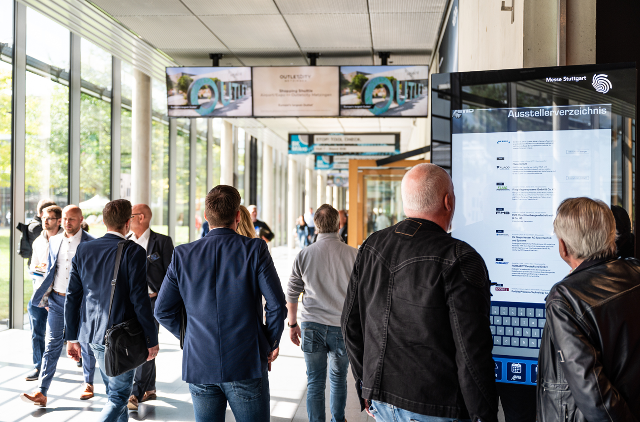 Presso il centro fieristico di Messe Stuttgart un visitatore utilizza un grande chiosco informativo touchscreen per accedere all'elenco online degli espositori di AMB. | Copyright: Messe Stuttgart