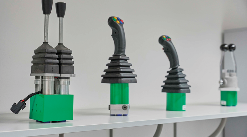 La gamma di joystick di Hydreco Hydraulics: in primo piano il mini-joystick elettrico proporzionale MHDC, con impugnatura MHC.